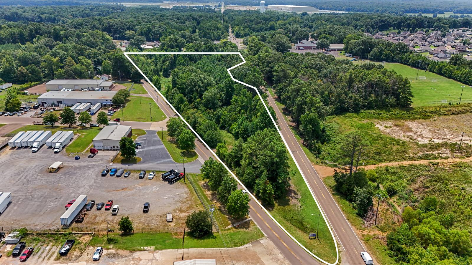 Aerial photo of a wooded roadside land parcel on Highway 51 with its property boundary outlined in white